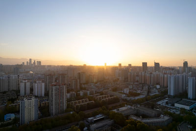 Cityscape against clear sky during sunset