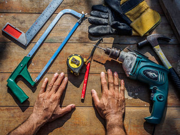 High angle view of man hands by tools on table
