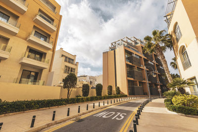 Road amidst buildings against sky