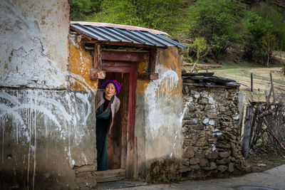 Rear view of woman standing against old building