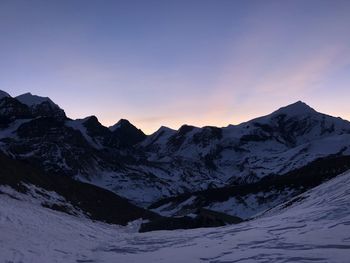 Scenic view of snowcapped mountains against sky during sunset