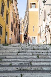 Female traveler walking on stairs on city street