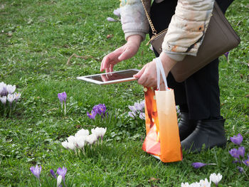 Rear view of women holding flowers on field