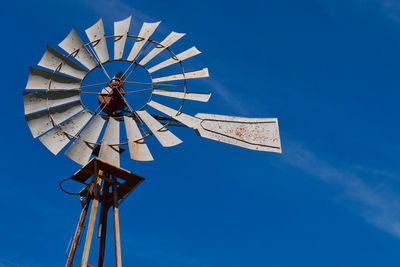 Low angle view of traditional windmill against blue sky