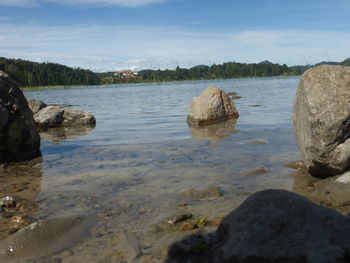 Scenic view of rocks in lake against sky