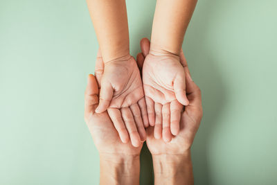 Cropped hand gesturing against blue background