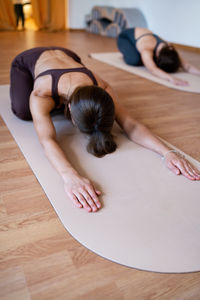 Side view of woman sitting on floor