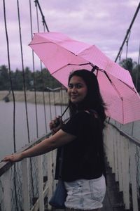Portrait of smiling woman standing in rain during rainy season