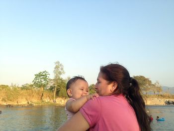 Mother and daughter against sky