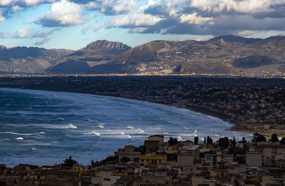 High angle view of townscape by sea against sky