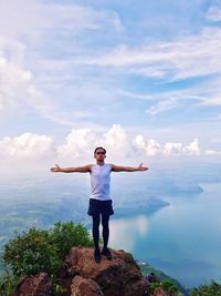 Full length of man standing on rock against sky