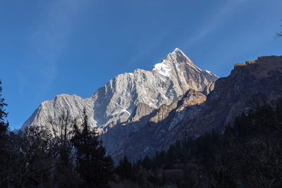 Scenic view of snowcapped mountains against blue sky