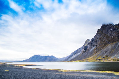 Scenic view of lake by mountains against sky