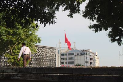 Man flag on city against sky