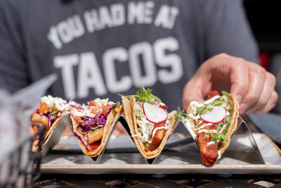 Closeup of man eating tacos outside in summer