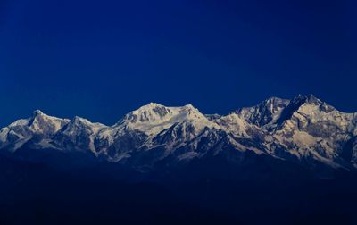 Scenic view of snowcapped mountains against clear blue sky