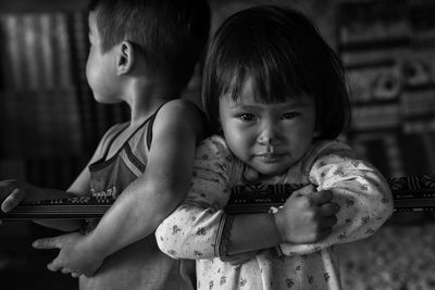 Portrait of cute girl with sibling at home