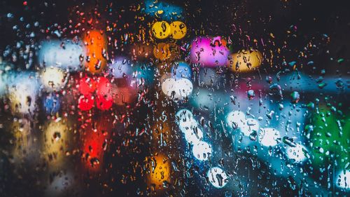 Defocused lights seen through wet window in rainy season