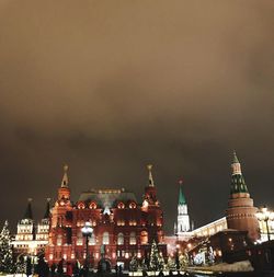 Illuminated buildings in city against sky