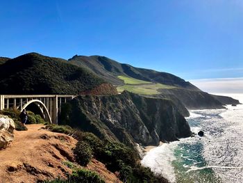 Arch bridge over sea against clear blue sky