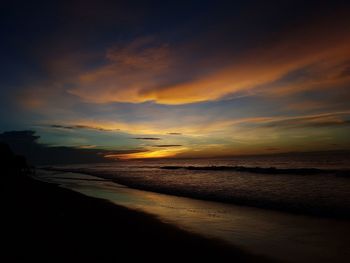 Scenic view of beach against dramatic sky