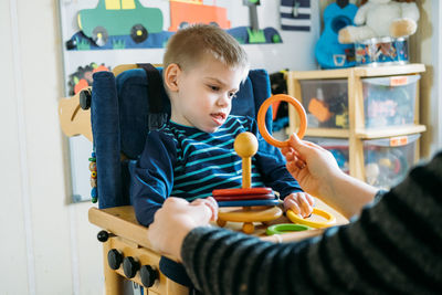 Cute boy playing with toy at home