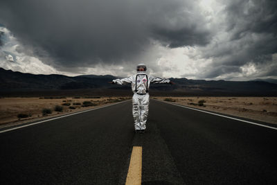 Rear view of woman walking on road against sky