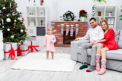 Portrait of smiling family sitting on sofa at home