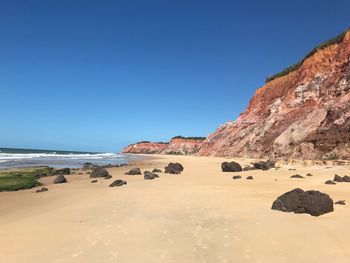 Scenic view of beach against clear blue sky