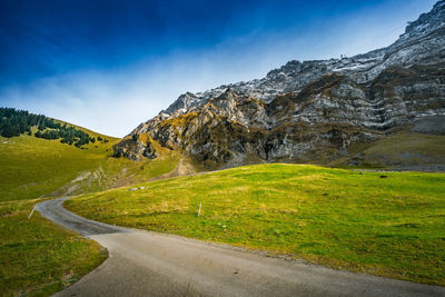 Road by mountain against sky