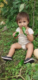 Cute baby girl sitting on field