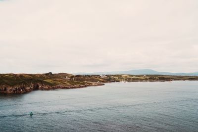 Scenic view of sea and mountains against sky