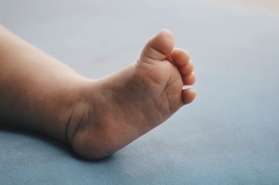 Low section of baby feet on bed