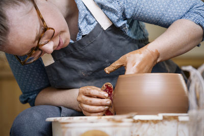 Close-up of woman molding shape on pottery wheel