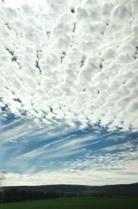 Scenic view of field against cloudy sky