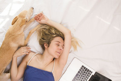 High angle view of young woman sleeping on bed at home