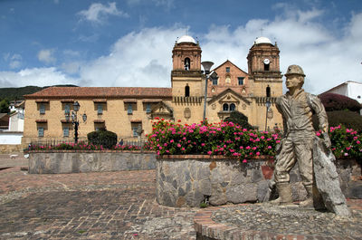 Statue against historic building in the town square