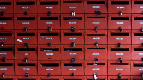 Full frame shot of closed red mailboxes at post office