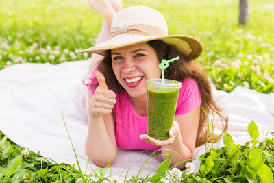 Portrait of a smiling young woman lying on grass