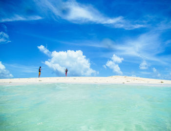 People on sea shore against sky