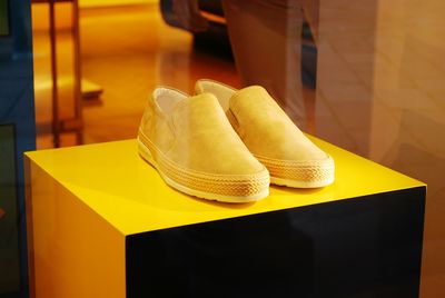 Close-up of yellow shoes on table