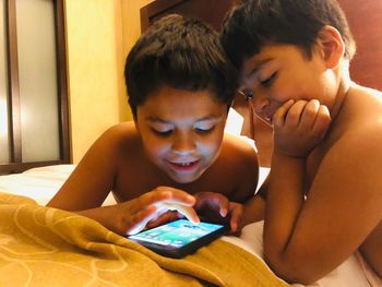 Cute boy using smart phone in laptop