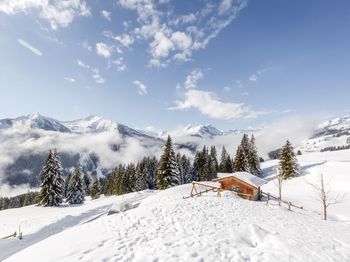 Snow covered land and mountains against sky