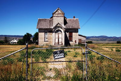 Built structure on field against clear blue sky