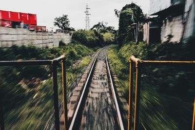 Railroad tracks by trees against sky