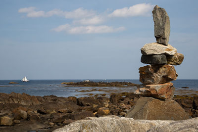 Stack of rocks on beach against sky