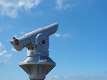 Low angle view of coin-operated binoculars against sky