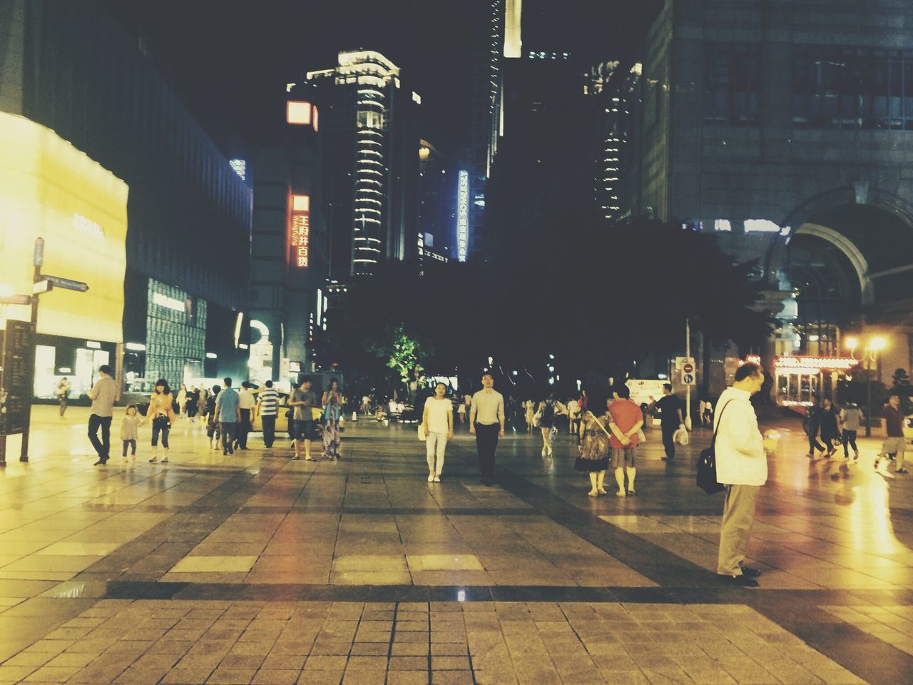 building exterior, city, architecture, built structure, illuminated, city life, night, street, large group of people, city street, walking, person, men, transportation, lifestyles, street light, building, incidental people, road