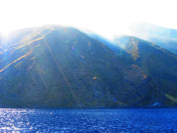 Scenic view of sea and mountains against sky