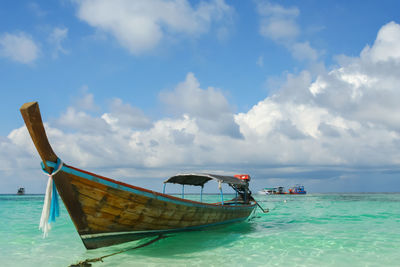 Boat moored in sea against sky